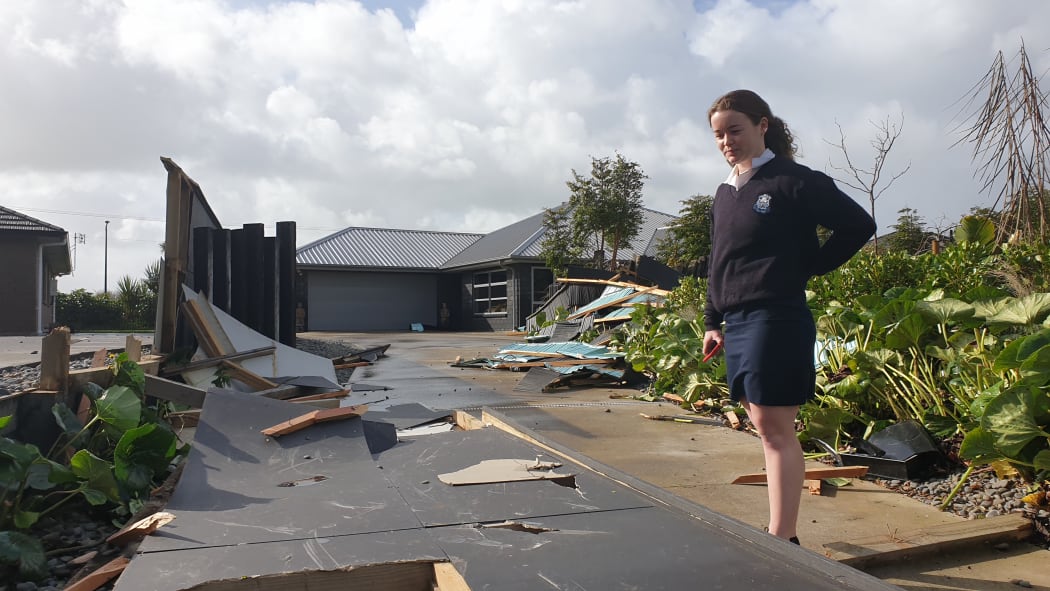 New Plymouth Girls High student is 17 year old Ciara Parkes stands in the debris  of a fence blown over.