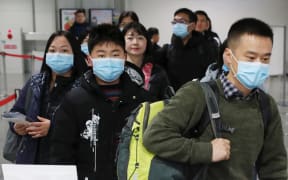 Passengers wearing mask walk at quarantine inspection during the time when a flight arrived from Wuhan at Kansai International Airport in Osaka.