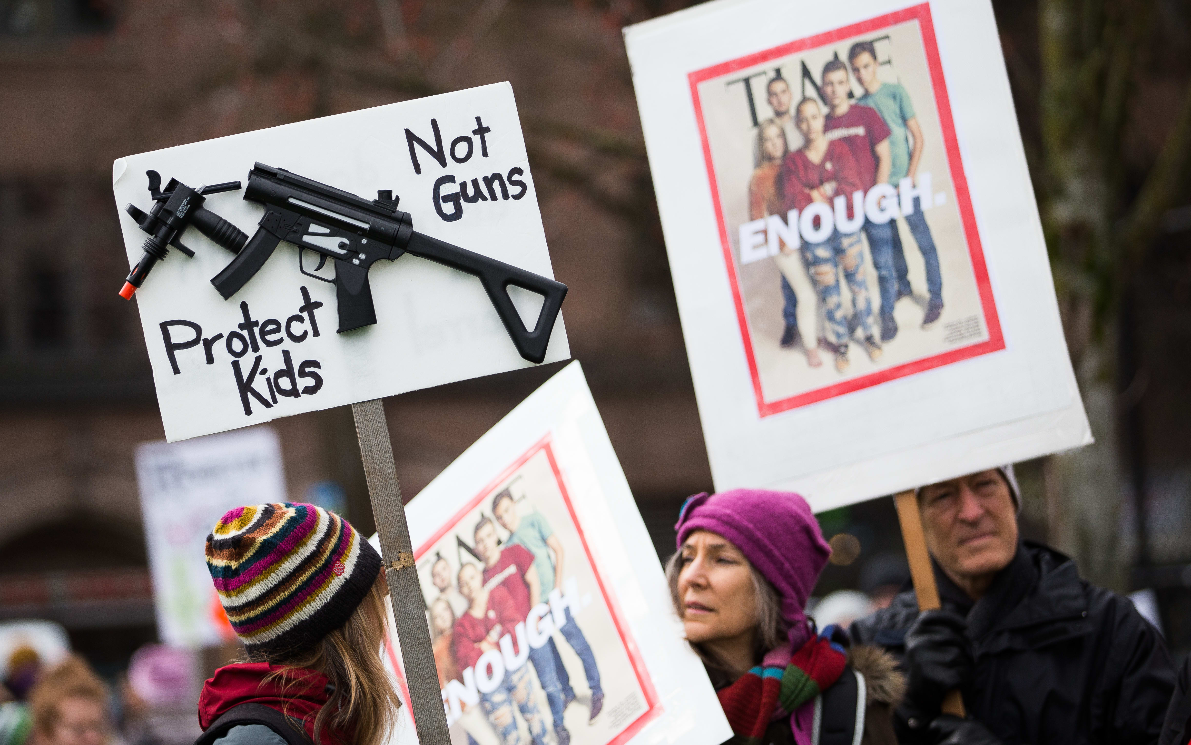 People hold signs during the March for Our Lives rally for Marjory Stoneman Douglas High School students in March 2018 in Seattle, Washington.