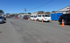 Queues of cars park outside the Kamo covid testing centre in sweltering heat.