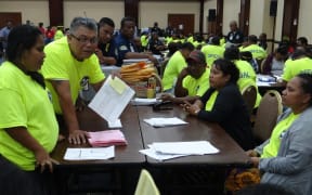 Marshall Islands Chief Electoral Officer Robson Almen (holding paper) talks to tabulators during the late November ballot counting in Majuro in 2015.