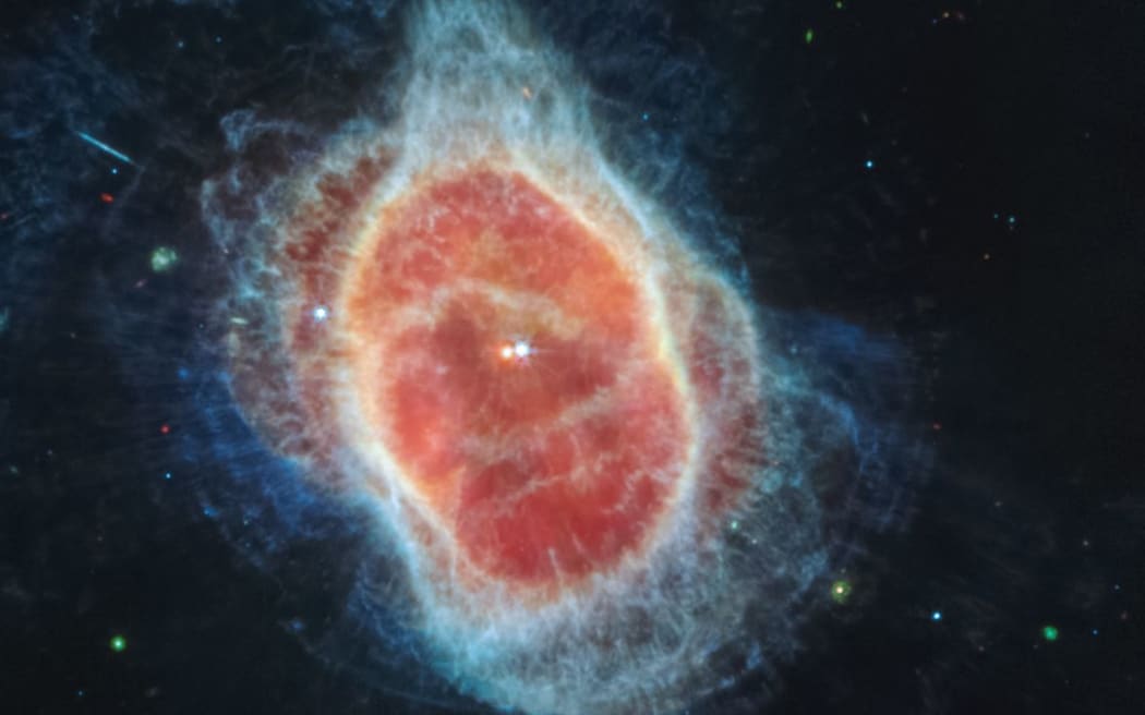 This image released by NASA on July 12, 2022, shows that the James Webb Space Telescope (JWST) has revealed the cloak of dust around the second star, shown at left in red, at the center of the Southern Ring Nebula for the first time. It is a hot dense white dwarf star. - The JWST is the most powerful telescope launched into space and it reached its final orbit around the sun, approximately 930,000 miles from Earths orbit, in January, 2022. The technological improvements of the JWST and distance from the sun will allow scientists to see much deeper into our universe with greater detail. (Photo by Handout / NASA / AFP) / RESTRICTED TO EDITORIAL USE - MANDATORY CREDIT "AFP PHOTO / NASA" - NO MARKETING NO ADVERTISING CAMPAIGNS - DISTRIBUTED AS A SERVICE TO CLIENTS