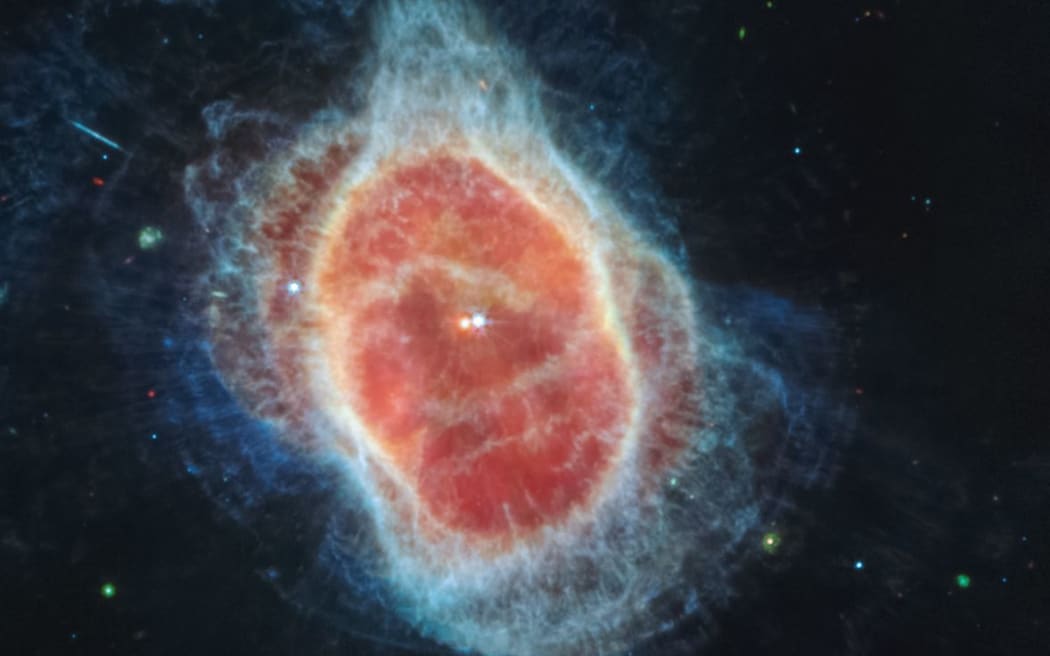 Esta imagen publicada por la NASA el 12 de julio de 2022 muestra que el Telescopio Espacial James Webb (JWST) detectó por primera vez un manto de polvo alrededor de la segunda estrella, que se muestra en rojo, en el centro de la Nebulosa del Anillo Sur.  .  Es una estrella enana blanca densa y caliente.  - JWST es el telescopio más poderoso jamás lanzado al espacio y alcanzó su órbita final alrededor del sol, a unas 930,000 millas de la órbita de la Tierra, en enero de 2022. Las mejoras tecnológicas de JWST y la distancia del sol permitirán a los científicos ver mucho más profundo en nuestro mundo en mayor detalle.  (Imagen vía comunicados / NASA / AFP) / Restringido para uso editorial - Acreditación obligatoria 