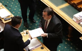 Finance Minister Grant Robertson hands the Budget Speech to National Party leader Simon Bridges.