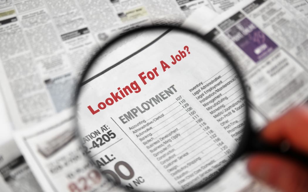 Magnifying glass over Jobs section of newspaper classifieds