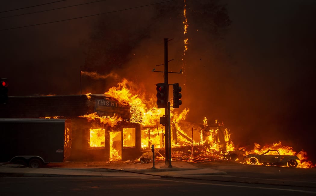 A store burns as the Camp fire tears through Paradise, California