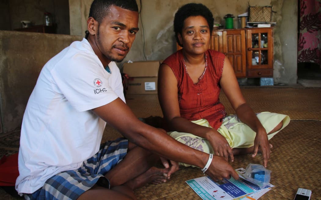 A Fijian villager receiving health advice from a Red Cross field worker