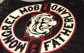 New Mongrel Mob patches on black leather  jerkins with Mongrel Mob, a bull dog and  Fatherland, lie on a table