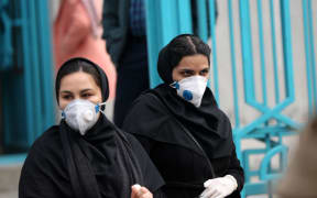 People wear masks after deaths and new confirmed cases revealed from the coronavirus in Tehran, Iran.