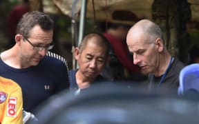 Two British divers John Volanthen (L) and Richard William Stanton (R) are seen with Thai rescue personnel at the Tham Luang cave area on July 3, 2018 after finding the children and football coach alive in the cave.