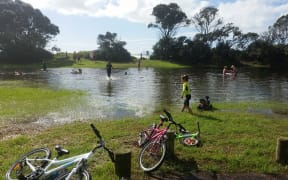 Children play in a newly-formed pool at a Waihi Beach park.
