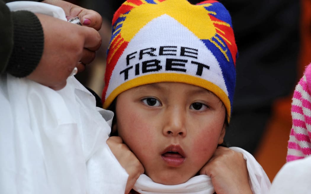 A child, wearing a Free Tibet hat, waits to catch a glimpse of Tibetan spiritual leader The Dalai Lama at the historical Mahabodhi Temple, where Lord Buddha attained enlightenment, in Bodhgaya in India's Bihar state on January 4, 2010. Exiled Tibetan spiritual leader The Dalai Lama will spend a week in Bodhgaya where he will pray and deliver teachings to followers at the Mahabodhi temple. AFP PHOTO/Diptendu DUTTA. (Photo by DIPTENDU DUTTA / AFP)