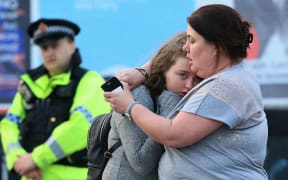 Vikki Baker and her thirteen year old daughter Charlotte hug outside the Manchester Arena