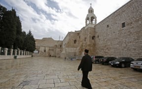 A priest walks past the Church of the Nativity in the West Bank city of Bethlehem, a day after spraying sanitisers as a preventive measure against the coronavirus, on March 6, 2020.