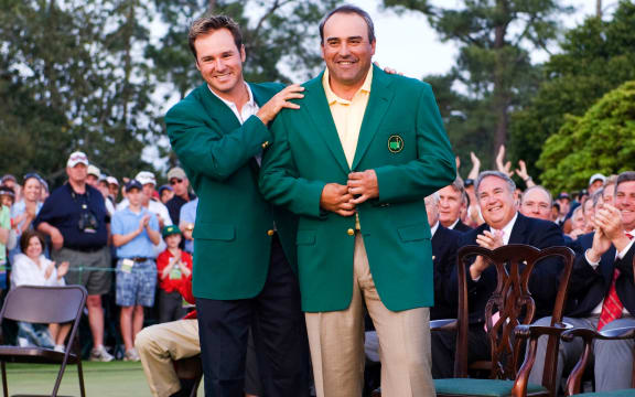 Angel Cabrera is presented with his green jacket by Trevor Immelman after winning the Masters in 2009.