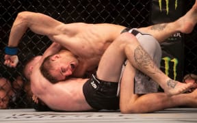 New Zealand fighter Dan Hooker grapples with Paul Felder in their UFC lightweight bout in Auckland.