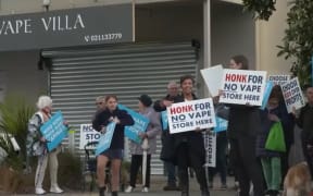 Some people from Parakai School community protest a vape shop and hold signs that read 'Honk for no vape store here'.