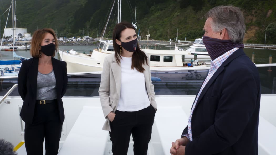 Prime Minister Jacinda Ardern (centre) viewing the electric ferry at Wellington Harbour with East By West managing director Jeremy Ward (right).