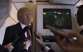 Donald Trump speaks to reporters on Airforce One.