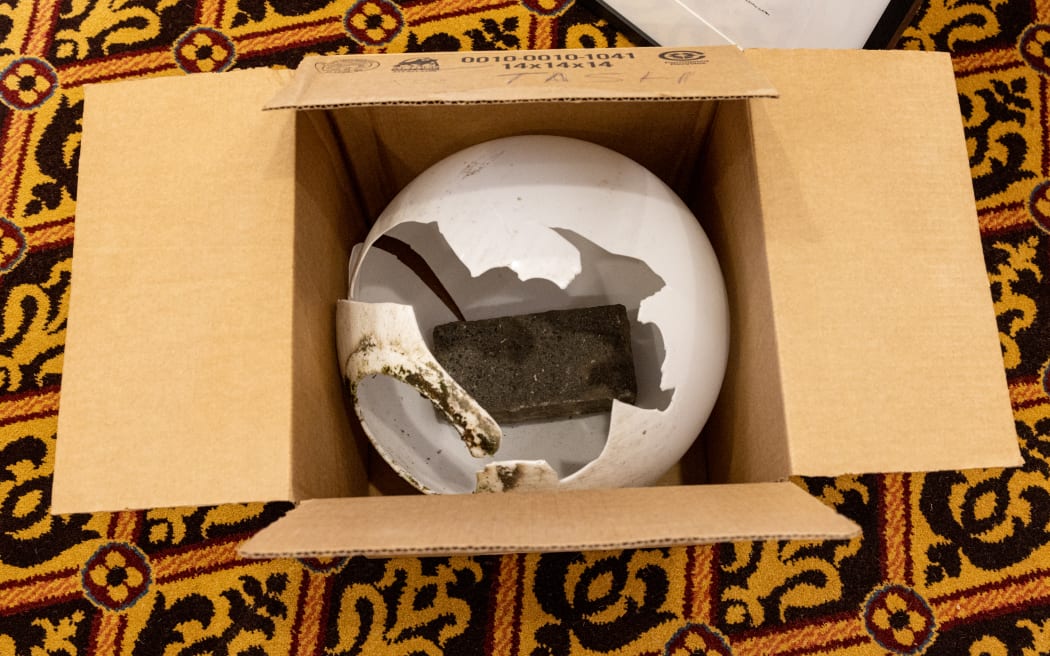 A brick caught in the broken ball of light it shattered during the protest - now part of Parliament's collection.