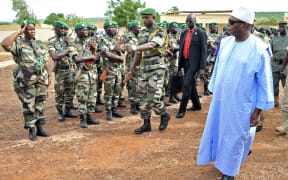 Mali's President Ibrahim Boubacar Keita (right) reviews troops in Kati, near Bamako.