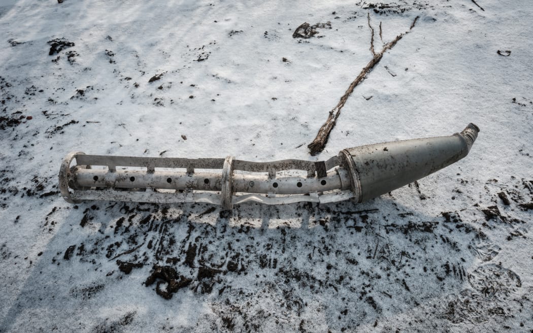 A casing of a cluster bomb rocket lays on the snow-covered ground in Zarichne on February 6, 2023, amid the Russian invasion of Ukraine.