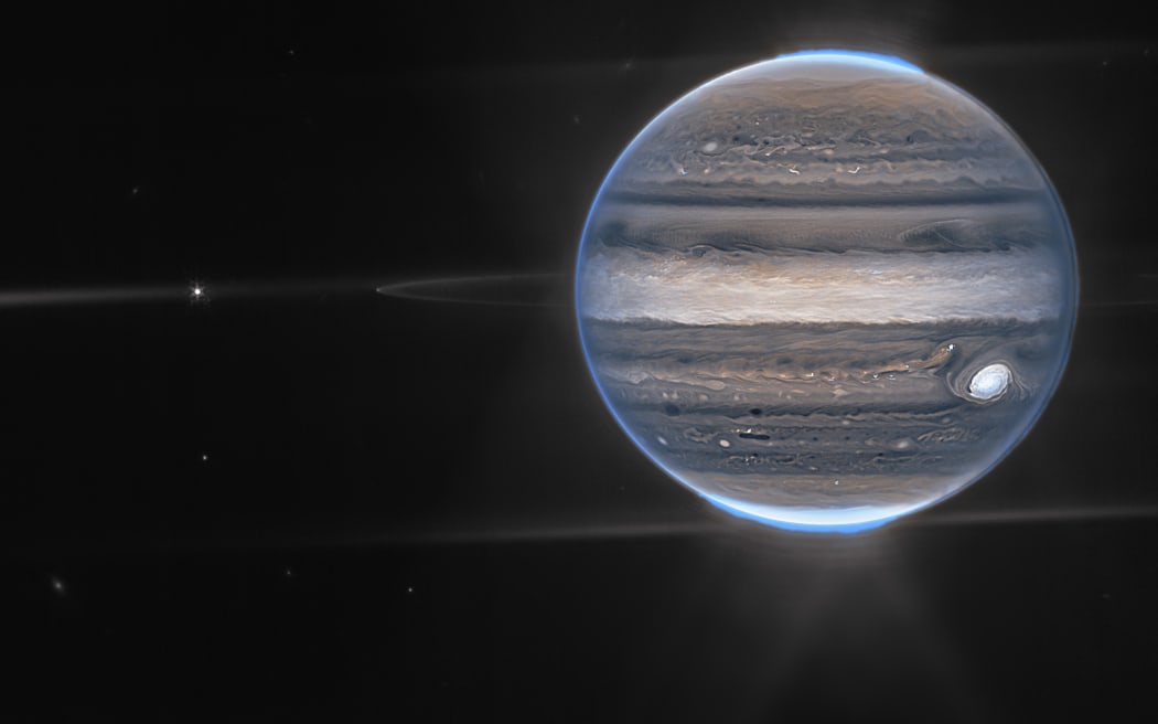 En esta imagen obtenida de la NASA y tomada por el Telescopio Espacial James Webb, se muestra a Júpiter en una vista de campo amplio, mostrando el planeta con sus tenues anillos, que son un millón de veces más tenues que el planeta, y dos pequeñas lunas llamadas Amaltea ( L) y Adrastea en el borde del ring.  (Foto por Leaflet / NASA / AFP) / RESTRINGIDO A USO EDITORIAL - CRÉDITO OBLIGATORIO 