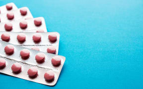 Pink tablets in blisters on a blue background. Many packages of pills in silvery blisters. Statins, enzymes, analgesics, antibiotic. Copy space. Healthy, Pharmacy and medical concept