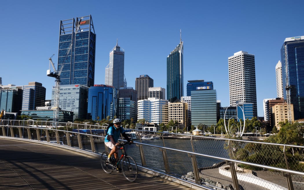 A cyclist rides along a deserted walkway in the normally busy Elizabeth Quay area in Perth on January 31, 2021,