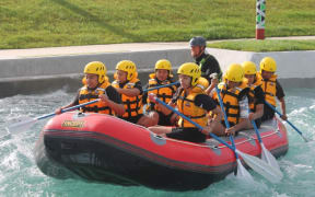 An image of students in an inflatable raft travelling down the whitewater river course.