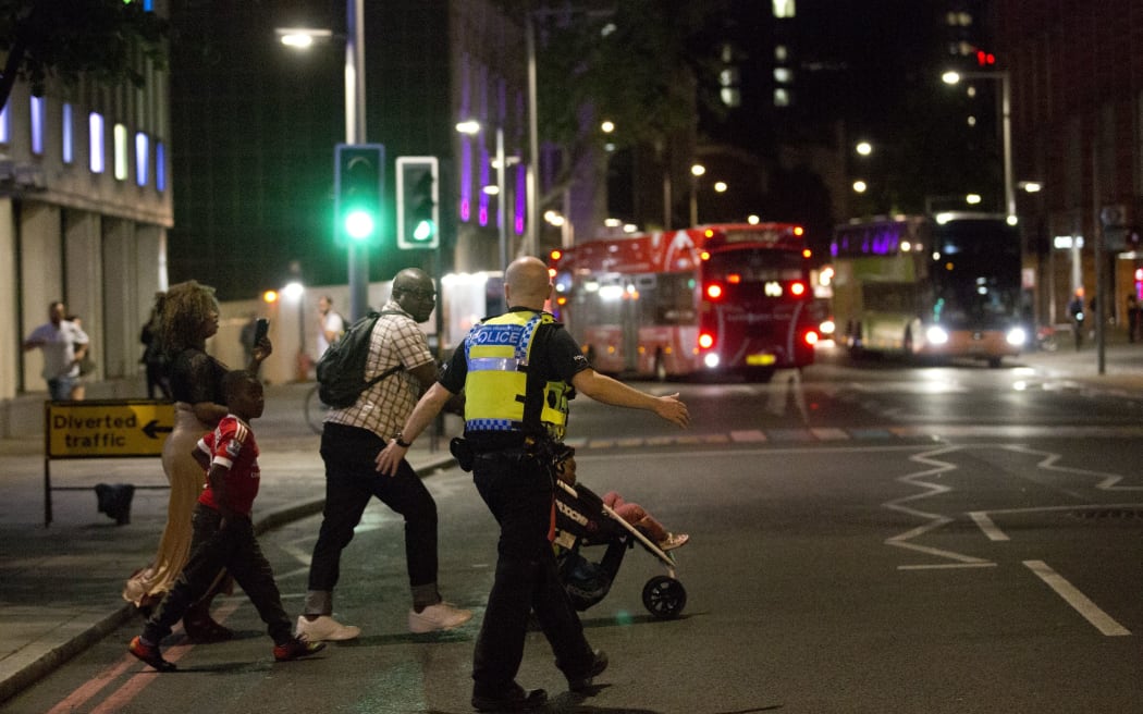 London police help escort people away from the scene of an apparent attack near London Bridge.
