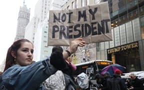 A woman (L) holding placard stating NOT MY PRESIDENT appeals her protest against the result of president election that Donald Trump will become the 45th President of the United States of America in next January, in front of the Trump Tower, Manhattan, New York on Nov.9, 2016