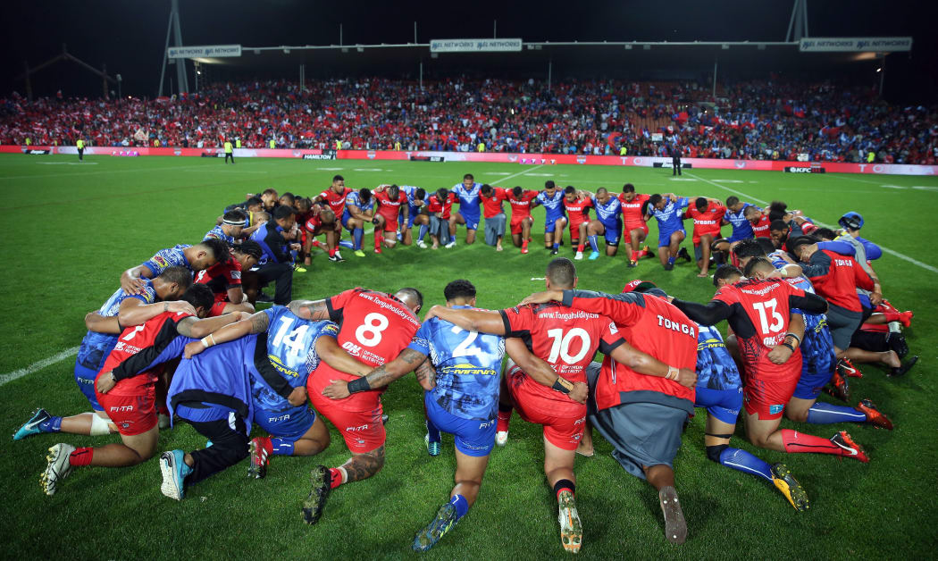 Tongan and Samoan players embrace in prayer