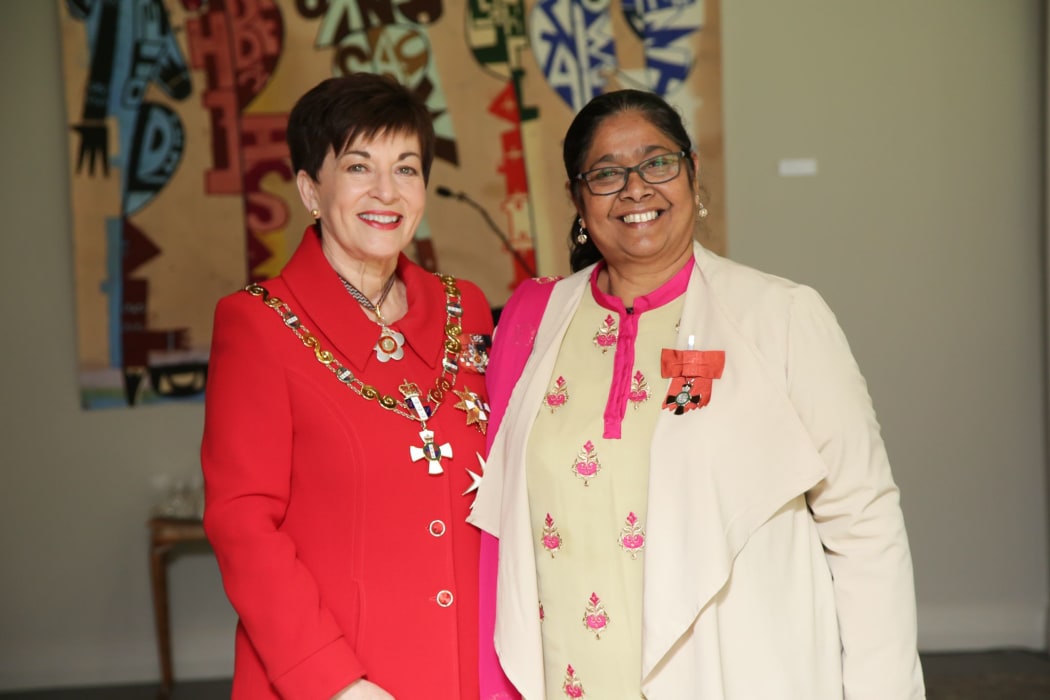 Human rights activist Jennifer Khan-Janif  (at right) is awarded an MNZM by former governor-general Dame Patsy Reddy.