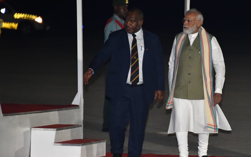 India's Prime Minister Narendra Modi, right, walks with Papua New Guinea counterpart James Marape at Port Moresby International Airport on 21 May, 2023