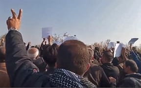 Video grabs from UGC images posted on 26 October 2022, show Iranian mourners marching towards Aichi cemetery in Saqez, to mark 40 days since Mahsa Amini's death.
