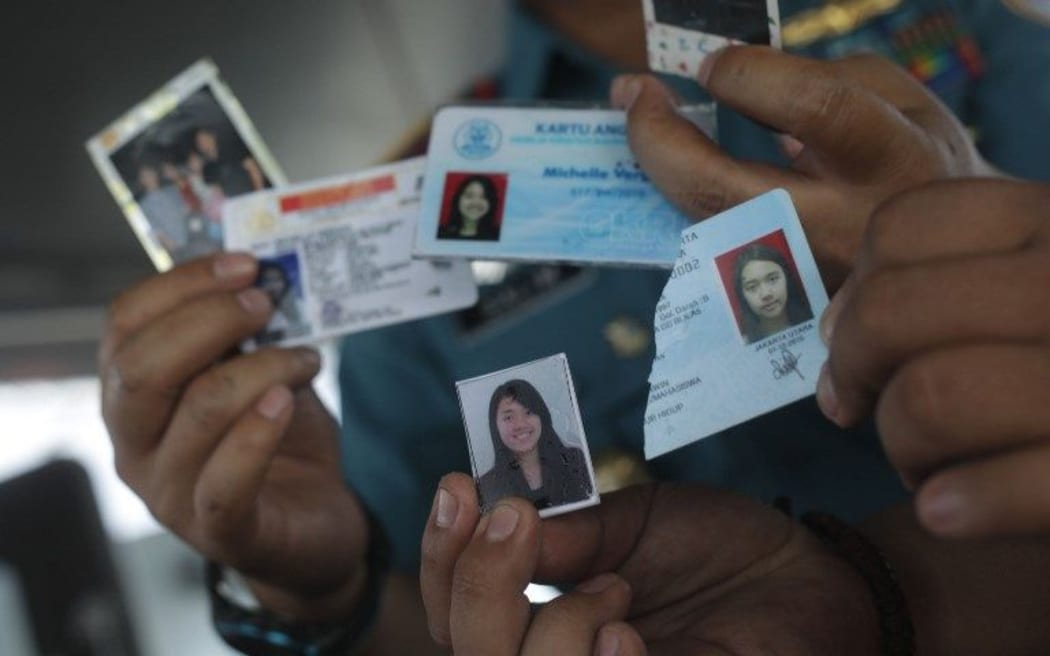 Searchers show IDs and photos found in the water after the Lion Air JT 610 plane crashed.