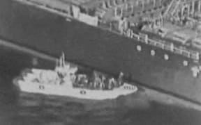This grab taken from a video released by the US Central Command (USCENTCOM) on June 13, 2019, reportedly shows an Iranian navy patrol boat in the Gulf of Oman approaching the Japanese operated methanol tanker Kokuka Courageous and removing an unexploded mine.