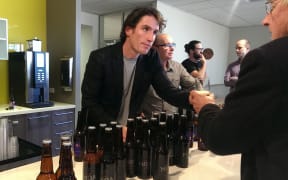 Moa founder Josh Scott serves beer to investors at the company's annual meeting in Auckland.