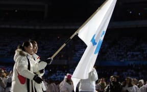 South Korea speed skater Bora Lee joined with Democratic People's Republic of Korea's figure skater Han Jong-In enter the Stadio Olimpico as they lead their delegation during the opening ceremony of the 2006 Winter Olympics.