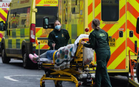 Paramedics transport a patient  from the ambulance to the emergency department at the the Royal London Hospital, on 15 January, 2021 in London, England.