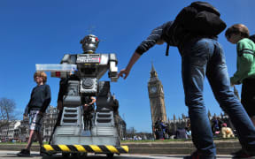 People look at a mock killer robot in central London at the launch of the "Campaign to Stop Killer Robots".
