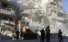 A tractor clears rubble away in Aleppo as relentless airstrikes on the city continue.