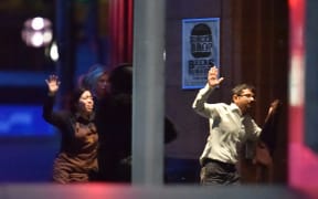 Hostages run out of the a cafe in the central business district of Sydney.