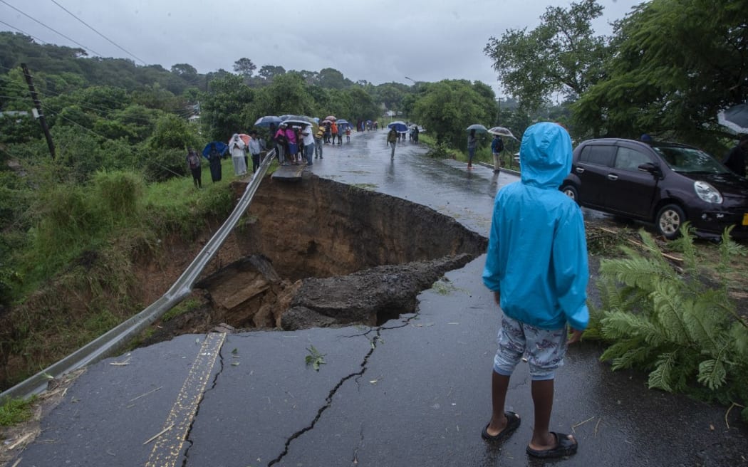 A general view of a collapsed road caused by flooding waters due to heavy rains following cyclone Freddy in Blantyre, Malawi, on March 13, 2013. - Malawi's leader on March 13, 2023 declared a state-of-disaster in several southern districts including the commercial hub Blantyre after the powerful cyclone Freddy made a come-back killing dozens. (Photo by Amos Gumulira / AFP)