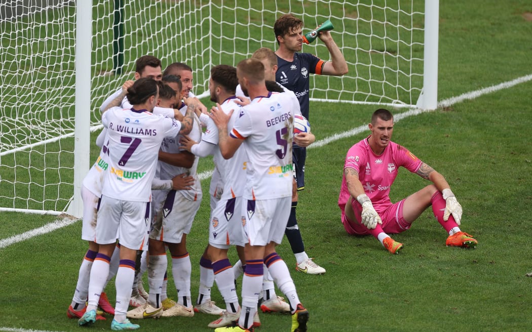 The Glory celebrate a goal as Phoenix's goal keeper Oli Sail sits dejected during their A-League match in Palmerston North.