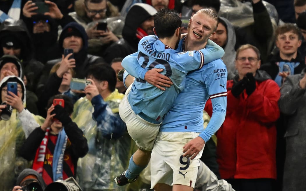 Manchester City striker Erling Haaland (R) celebrates with Bernardo Silva after scoring during the Champions League quarter final, first leg match against Bayern Munich,