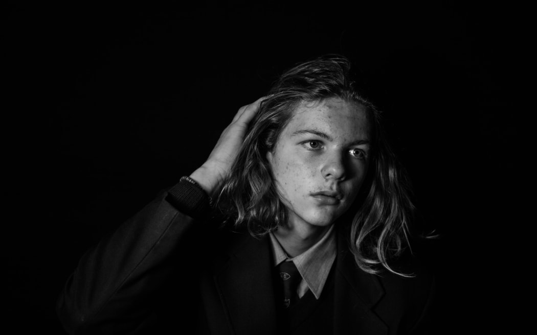 teenage boy with long hair in black and white