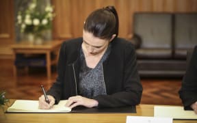 Prime Minister Jacinda Ardern signs the Condolence Book.