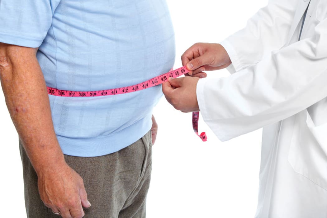 Doctor measuring waist of obese man (stock shot).